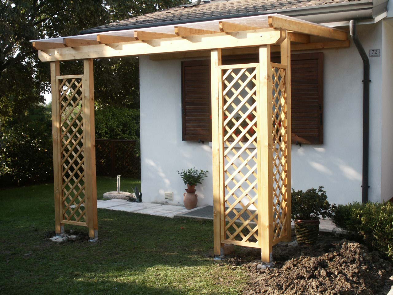 Pergola adossata con copertura in policarbonato e con grigliati